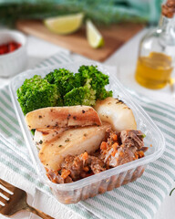 marmita pequena de comida saudável fit, com arroz integral, batata doce, carne bovina cozida com cenoura e brócolis japonês, sobre pano de prato com azeite no azeiteiro e limão com pimenta