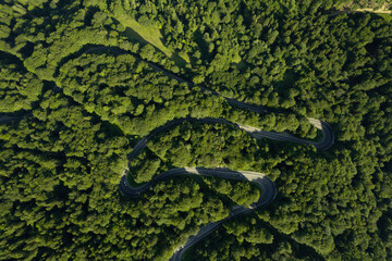 Aerial view of the road passing through the mountain and green forest. Curve asphalt road on mountain.	
