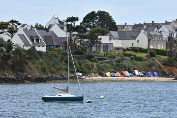 Un petit bateau à voile, amarré près d'une plage en Bretagne 