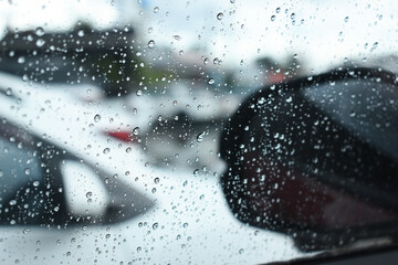 side mirror of car in rainy day, water drop on glass