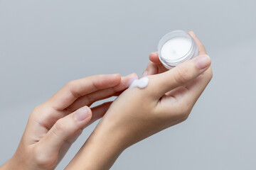a woman applies a cosmetic cream on her hands. hand skin care concept