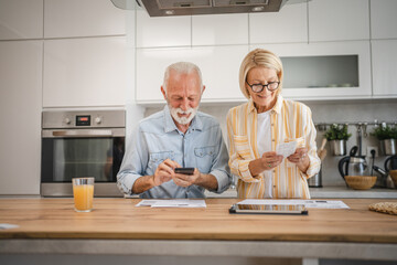 Senior man have contact less payment and mature woman read invoice