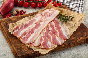 Sliced pork bacon over board