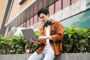 Handsome long legs of Asian men walking, listening to music and working on the street © Q88