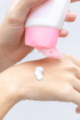 Close up woman hands squeeze cream or lotion drop on hand before apply on her face. Self care of young healthy female apply cream on body after shower for moisturizing on skin. Woman self care concept