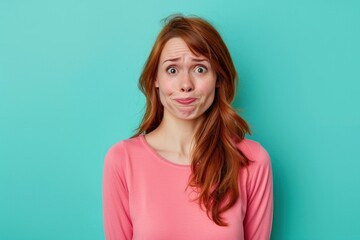 Fototapeta premium Uncomfortable and Uncertain, woman with an Awkward Expression Making a Goofy Face Isolated color background