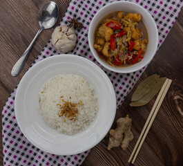ginger chicken with rice, with uncooked ingredients as garnish
