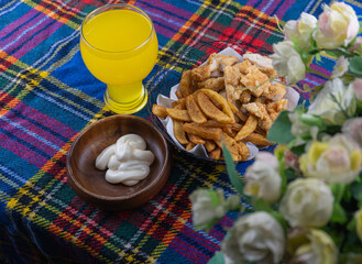 potato wedges with mayonnaise with orange juice on a picnic blanket and flower on the background. 