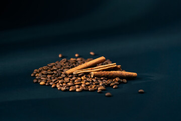 close-up on a black and blue background roasted coffee beans lie laid out on a background with...
