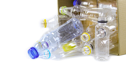 Clear plastic bottles on a white surface, awaiting recycling.