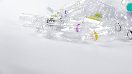 Clear plastic bottles on a white surface, awaiting recycling.