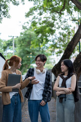 Three young people are walking down a sidewalk, smiling