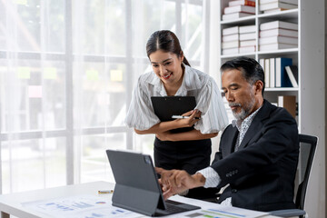A woman and a man are working together on a laptop