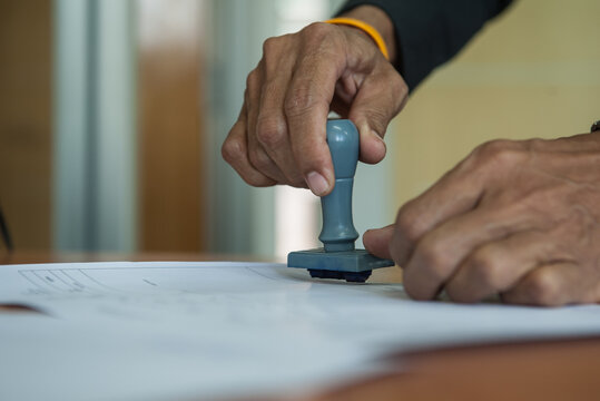 Stamping a document with a rubber stamp.