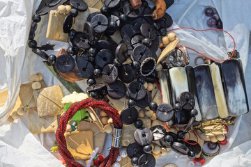 a bunch of jewelry and colorful ornaments in a white plastic cellophane bag