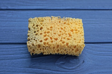 one yellow old foam sponge lie on a black wooden table