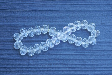 white plastic beads lie on a black wooden table