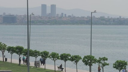 Istanbul, Turkey - May 10 2024: People enjoy a walk on the seafront street in Istanbul