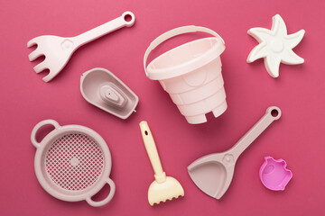 Cute toys for playing with sand on color background, top view