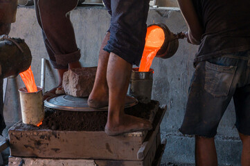 Artisan Aluminum Foundry Workers Pouring Molten Metal into Molds