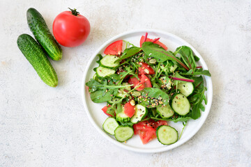 a plate of salad with cucumber and tomatoes covered with flex seeds 