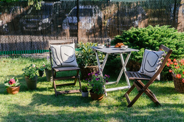 Garden table setting with folding chairs and pillows