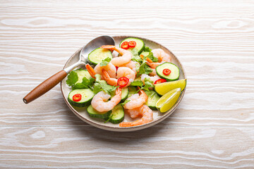Delicious shrimp salad with fresh ingredients on white table, perfect for healthy meals in summer. Top down view of prawn with vegetables salad, ideal for showcasing culinary skills
