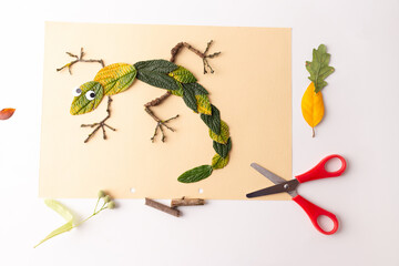 Fototapeta premium Abstract lizard crafted from autumn leaves in a foliage flat lay composition. Natural textures and colors create a whimsical interpretation of a lizard using seasonal foliage