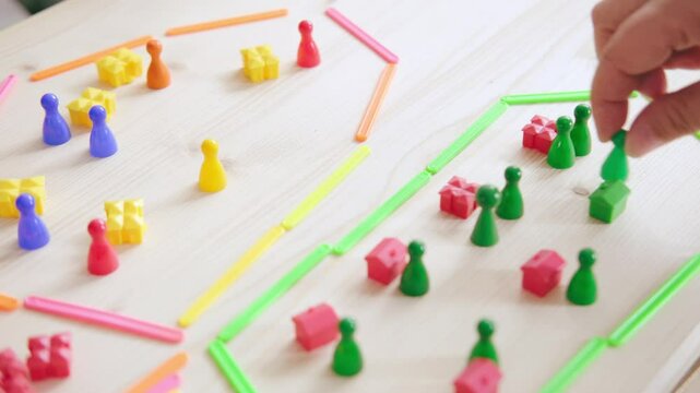 Child and adult enjoy interactive math game with colorful plastic counters and counting sticks, fine motor skills, Early childhood development, Bonding time, Hands-on learning