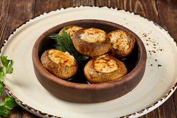 Baked Mushrooms with Cheese and Bacon in Ketsi Dish on Rustic Plate