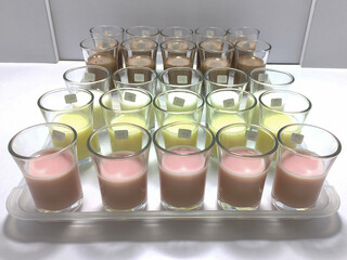 A lineup of sample glasses for sensory testing of dairy products in various flavors. This detailed setup showcases a professional quality control process.