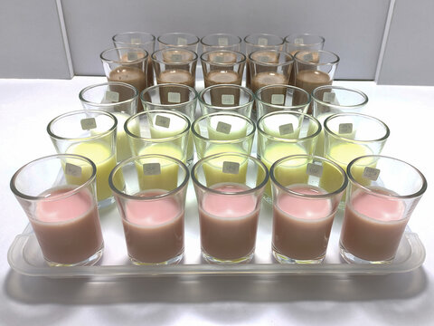 A lineup of sample glasses for sensory testing of dairy products in various flavors. This detailed setup showcases a professional quality control process.