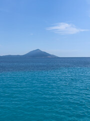 blue sea with a mountain in the background