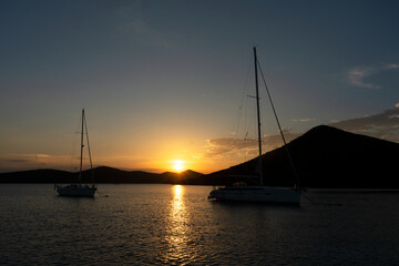 sailboats at the sunset with mountains