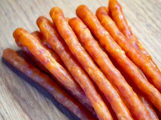 Brightly lit sausages on a wooden surface, likely to entice meat enthusiasts.
