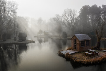 Obraz premium Szodliget, Hungary - Aerial view of a dreamy winter scene at Szodliget fishing lake with fishing huts and heavy fog on a cold winter morning