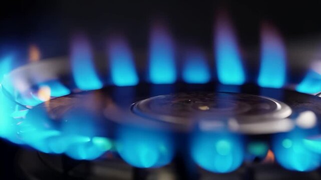 Close-up of blue flames on gas stove burner in slow motion for culinary and cooking concepts