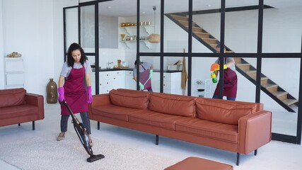 Timelapse of three cleaners meticulously disinfect, sanitize, and vacuum a stylish living room, showcasing professional cleaning expertise