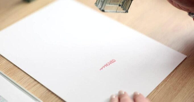 Woman leaves stamp Approved on blank paper sheet in office slow motion. Clerk puts mark on official document at workplace. Request authorized