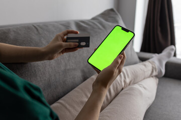The girl uses a bank card. Sale. Green screen on the phone.