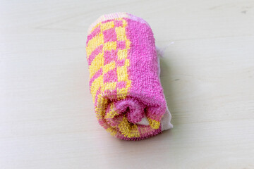 Rolled towel on light wooden surface. Bathroom and resort concept.