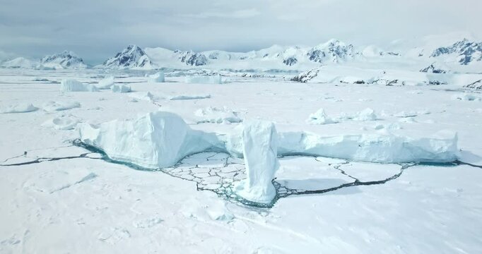 Amazing frozen arctic polar nature landscape. Snow covered icebergs, glacier and mountain range. towering ocean cost bay. Polar cold landscape. Antarctic travel and exploration. Aerial drone flight