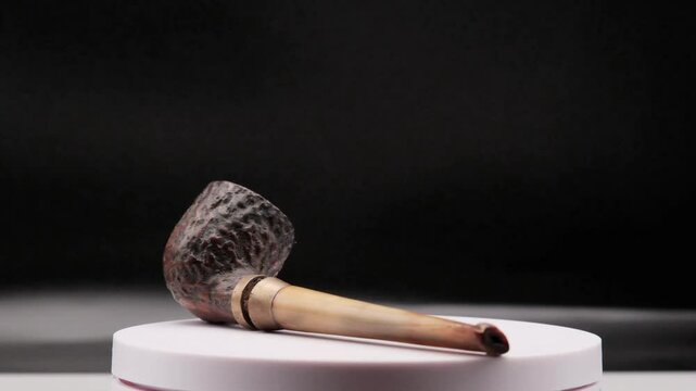 4k video of an ancient wooden pipe for smoking tobacco, which rotates on itself on a white background