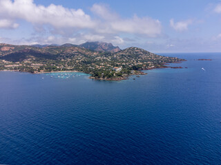 Obraz premium Panoramic view from above on blue Mediterranean dea, sandy beach of Agay town, summer vacation destination near Esterel mountains, French Riviera, Provence. France