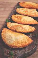 fried chebureks, deep-fried, mini, on a chopping board, wooden table, close-up, no people,