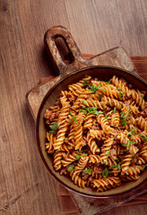 pasta in the navy, pasta with minced meat, plate on a wooden table, homemade, fusilli pasta, without people,
