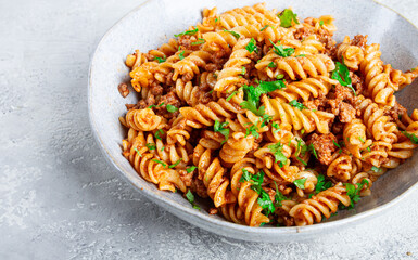 pasta in navy, pasta with minced meat, gray background, homemade, fusilli pasta, no people,