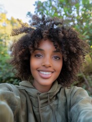 A woman with curly hair is taking a selfie