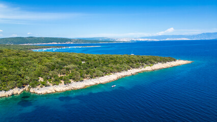 An aerial view of the Blue Lagoon at Plaža Krušćica and Tarej Beach on the island of Cres, showcasing their fantastic turquoise waters and surrounding islands. Boats dot the serene lagoon