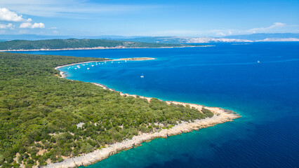 Fototapeta premium An aerial view of the Blue Lagoon at Plaža Krušćica and Tarej Beach on the island of Cres, showcasing their fantastic turquoise waters and surrounding islands. Boats dot the serene lagoon